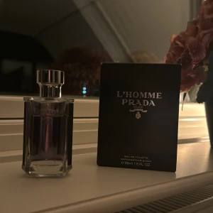 L'Homme Prada Eau de Toilette - Säljer en elegant L'Homme Prada Eau de Toilette. Flaskan är stilren med en genomskinlig design och ett silverfärgat lock. Doften är klassisk och maskulin, perfekt för både vardag och speciella tillfällen. Innehåller 50 ml. Passa på att köpa denna lyxiga parfym! 💙