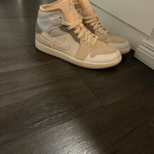 Beige Nike Air Jordans - Säljer ett par snygga beige Nike Air Jordans i mycket bra skick. Säljer pga dem inte används någon gång. De har en stilren design med snörning och en hög modell som ger bra stöd. Perfekta för både vardag och festligheter!! Priset kan diskuteras vid snabb affär!!