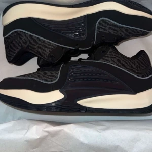 KD 16s Svarta basket skor  - Säljer ett par snygga kd 16s med vit sula och coola detaljer. Skorna har snörning och en modern design med svarta och gråa mönster. Perfekta för basketen. De är i mycket bra skick och redo för nya äventyr! Har använt dem bara 1 gång. 