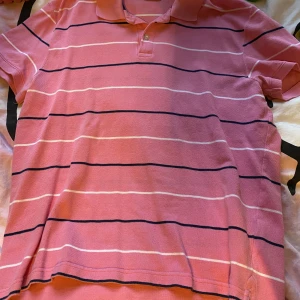 Hm rosa randig pikétröja storlek L - Säljer denna fina pikétröja. köpt second hand märket är hm. Tömmer min garderob med kläder jag knappt använder/ aldrig använt ?? nästan allt är thriftat. Om ni har några frågor skicka gärna ett dm :) jag kan också samfrakta