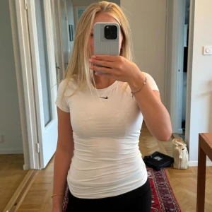 Nike topp - En vit tight tränings tröja som format kroppen fint. Nästan aldrig använd och i så bra skick. 