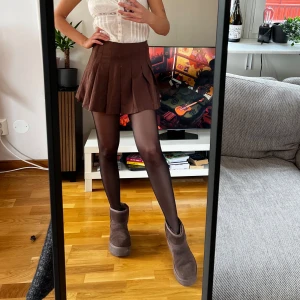 H&M brun minikjol - Brun minikjol från HM. Mycket bra skick och väldigt söt. Passar super nu till hösten med ett par tights och boots. 