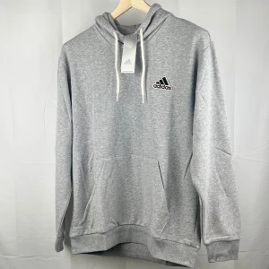 Adidas - Hoodie - Fräsch oanvänd grå hoodie med ficka vid magen och snöre för att justera luvan.  Material 70% Bomull 30% Polyester