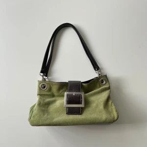 Handväska - Grön handväska i mocka / suede som rymmer mycket. Bredd: 28 cm. Djup: ca 11 cm. Höjd: 20 cm. Har några defekter som syns på bilderna 🤎