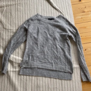 Grå stickad  - Grå lite tajt tröja i strl M men passar som S. Har mönster invirkat. Bra skick.