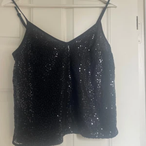 Glitter topp  - En jätte fin glitter topp som är svart men har ton av blå i sig i vissa ljus. Toppen är i storlek 36 men den passar alt ifrån xs-s 