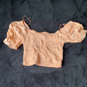 Topp - En blommig topp med puff armar 