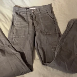 Grå cargobyxor - Säljer ett par gröna cargobyxor i bra skick. De har flera praktiska fickor och en avslappnad passform. Perfekta för en casual look eller utomhusaktiviteter. Passar till det mesta och är superbekväma!