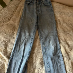 Ljusblå jeans från Momokrom - Säljer ett par ljusblå jeans från Momokrom i storlek EU 36. De har en klassisk straight fit och är perfekta för vardagsbruk. Jeansen är i bra skick och har en snygg tvättad look. Perfekta för både vår och sommar!