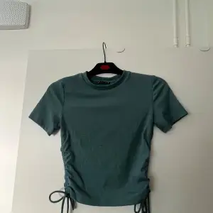 Blågrön T-shirt från zara med knytning vid sidorna  Nästintill oanvänd!