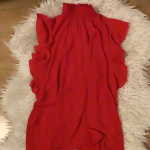 Röd blus från gina tricot - Säljer en superfin röd blus från Gina Tricot i storlek 38. Den har en hög krage och volangdetaljer längs sidorna som ger en extra touch. Perfekt för festliga tillfällen! 💃pris kan alltid diskuteras💗💗