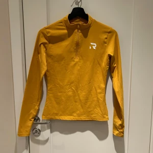 Långärmad Träningstopp  - Långärmad Träningstopp från Relode. Storlekslappen är bortklippt, men skulle säga att det är en mindre M/L storlek.   Senapsgul färg, finns inte att köpa längre.