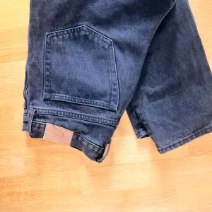 Säljer ett par snygga svarta jeansshorts från Weekday. De har en klassisk femficksdesign och en knappgylf. Perfekta för en avslappnad stil i sommar!