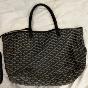 Handväska  - Använd men i väldigt gott skick. Köpt utomlands men är väldigt trovärdig. Prislapp och kort med. Plånbok som hänger på medföljer. Några små fläckar på insidan av väskan annars inga fel! Skriv för fler bilder .