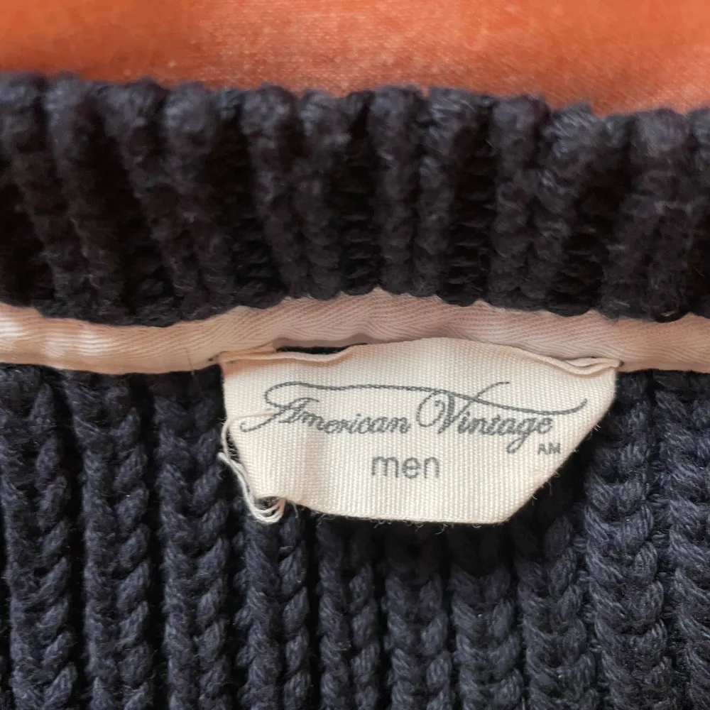 Säljer en stilren svart stickad tröja från American Vintage. Tröjan har en klassisk rund hals och långa ärmar, perfekt för kyligare dagar. Den är mjuk och bekväm, idealisk för både vardag och avslappnade tillfällen.. Neuletakit & Villapaidat.