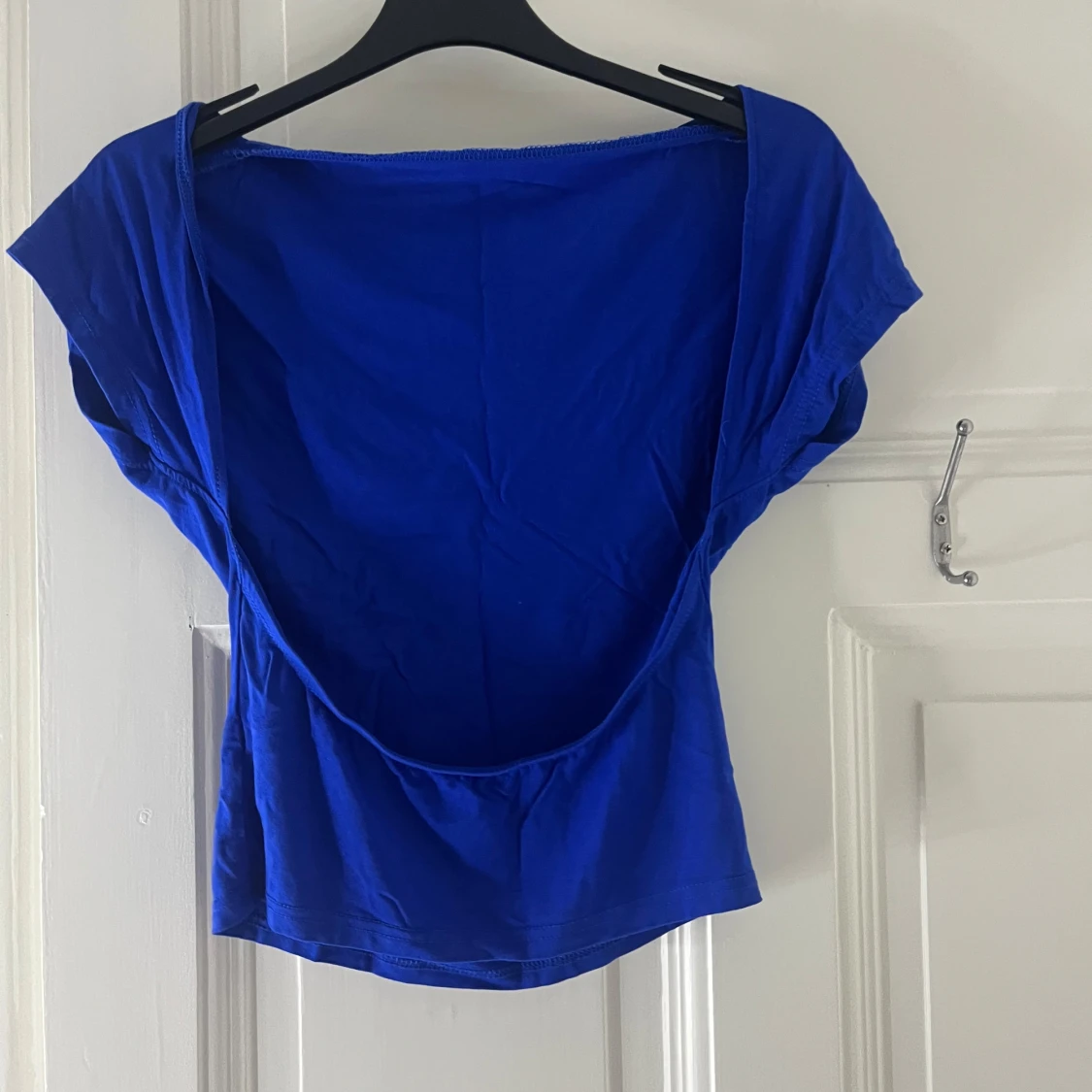 Blå topp som är öppen i ryggen