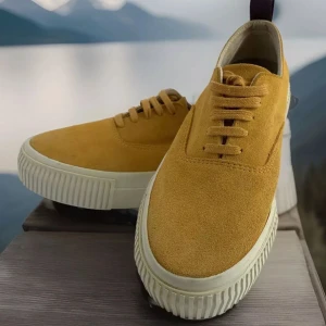 Gula sneakers i mocka - Snygga gula sneakers i mocka med vit sula och snörning. Perfekta för en färgglad stil. De har en praktisk flik baktill för enkel påtagning.