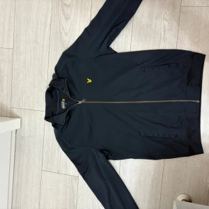 Lyle & Scott Kofta - Lyle and Scott kofta, knappt använd och i utmärkt skick. Mörkblå färg och är i storlek M.