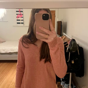 Rosa tröja från VILA - Säljer en mjuk och stilren rosa tröja från VILA. Tröjan har en v-ringad hals och långa ärmar, perfekt för en avslappnad look. Den är tillverkad i ett bekvämt material som passar bra till både jeans och kjol. Storlek: S