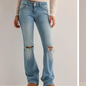 Ljusblå bootcut jeans med slitningar - Snygga ljusblå bootcut jeans med slitningar på knäna. Säljer för dem vart för långa och lite för stora i midjan. Bara testade. Nypris 700kr
