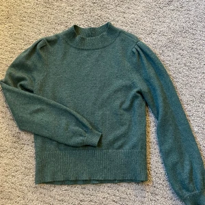 Grön tröja från Vila - Säljer en stilren grön tröja från Vila i storlek S. Tröjan har långa ärmar och en ribbad krage samt nederkant. Perfekt för kyligare dagar. Köparen står för frakten. Priset kan sänkas vid snabb affär.💗