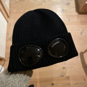 CP company mössa - Använd några gånger nu under denna vintern. Inga lösa fibrer eller spår av användning och plastfilmen över glaset är kvar. Kan skicka med prislappen också om det önskas