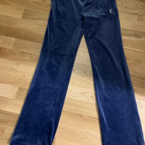 Juicy Couture velour trackbyxor - Helt nya och oanvända supersköna velour byxor från Juicy Couture med dragsko i midja i blå färg, strlk small