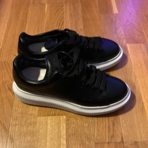 Svarta sneakers från Alexander McQueen - Säljer ett par Alexander McQueen skor då jag råkade beställa fel storlek. Skorna är i princip nya, inga skador eller defekter. Tyvärr finns ingen låda eller extra snören till.