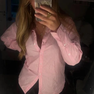 Rosa randig skjorta NAKD🩷 - Snygg rosa randig skjorta med knappar framtill. Skjortan är i superfint skick och sparsamt använd. Från nakd i storlek 40🩷😚🥰🍸