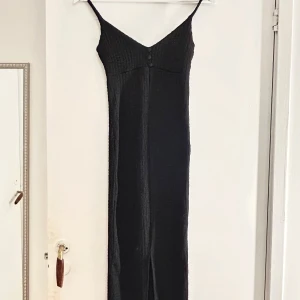Svart långklänning med knappar - Säljer en tight svart långklänning i ett ribbat material i storlek Xs från Gina Tricot. Har aldrig använts!💕