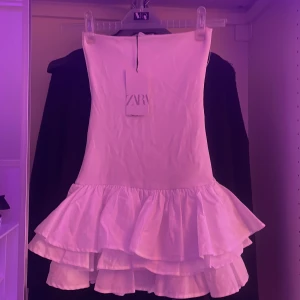 Zara klänning - Volangjklänning utan band nyskick, aldrig använd med prislapp kvar. Säljer pga för liten storlek Nypris 400 säljer för 200. Hör av er om ni har några frågor💕