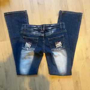 Lågmidjade hello kitty jeans - Lågmidjade jeans med hello kitty. Det gör ont i mig aaså men säljer för jag behöver pengarna😭 MÅTT: midja - 38cm | gren - 16 cm | innerben - 79 cm |ytterben - 109 cm  Köp med instabox innan 20.30 så postas paketet samma dag🩷