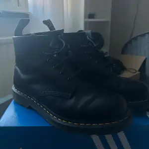 Säljer ett par svarta kängor i skinn från  dr. martens med den klassiska gula sömmen runt sulan. De har snörning framtill och en dragflik bak för enkel påtagning. Använda bara några gånger men lite slitningar, bilderna visar tydligt🖤