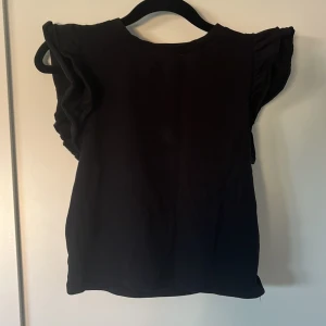 T-shirt med volang ärmar - Jättefin t-shirt från lager 157 i storlek S med volangärmar. Köparen står för frakten. Skriv vid intresse eller frågor.