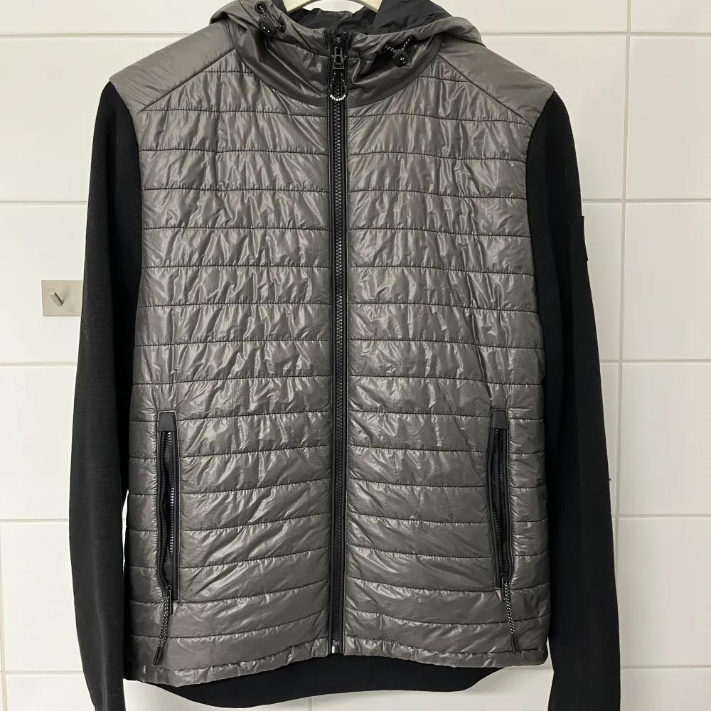 Säljer en snygg svart cardigan jacka från Belstaff i storlek S. Jackan har en quiltad framsida. Ärmarna och baksidan är i ett mjukare material. Perfekt nu till hösten och till våren! Skick 9/10. Frågor och funderingar? Hör bara av dig. Jackor.