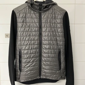 Svart belstaff cardigan - Säljer en snygg svart cardigan jacka från Belstaff i storlek S. Jackan har en quiltad framsida. Ärmarna och baksidan är i ett mjukare material. Perfekt nu till hösten och till våren! Skick 9/10. Frågor och funderingar? Hör bara av dig