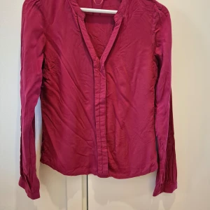 Tunika/skjorta/blus Vila - Tunika/skjorta/blus mörkrosa från Vila. Använd några gånger. Faller väldigt fint på kroppen. Väldigt behaglig material. V-ringad. Storlek XS. 100% viskos. 