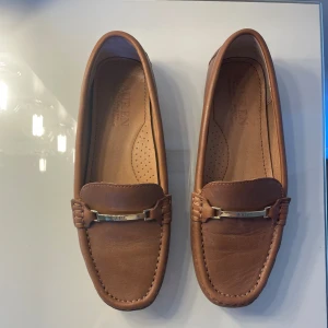 Ralph Lauren mockasiner stl 36  - Säljer mina bruna Ralph Lauren-mokasiner i 100% läder, storlek 36. Använda endast ett fåtal gånger då jag fick större fötter efter barnen och nu använder en storlek större.  Nypris: 1 390 kr, säljes för 450 kr.