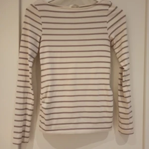 Beige och rosa randig långärmad tröja - Väldigt fin långärmad gravid tröja från h&m🌟 Storlek XS. Jag har sytt upp tröjan men det går lätt att sprätta upp.  Inte använd av mig så säljer vidare💕