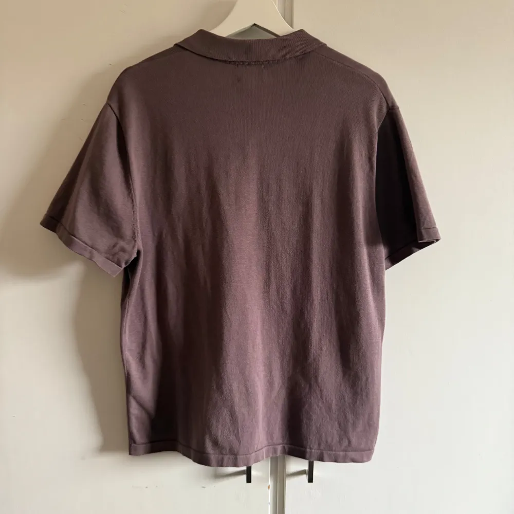 Säljer en stilren lila kortärmad skjorta från H&M. Skjortan har en klassisk krage och knappar framtill samt en bröstficka. Perfekt för en avslappnad look. . Paidat.