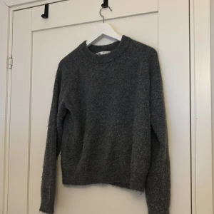 Mörkgrå tröja från Zara - Säljer en stilren mörkgrå tröja från Zara. Tröjan har en klassisk design med långa ärmar och rund hals. Perfekt för kyligare dagar och enkel att matcha med olika outfits. Nypris ca 400
