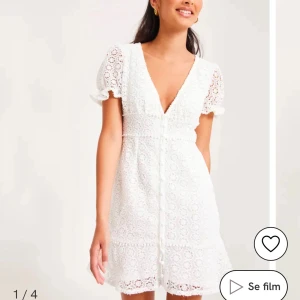 Studentklänning  - Säljer en söt vit spetsklänning från Kiss the sky med korta ärmar och v-ringning. Klänningen har fina spetsdetaljer och en knäppning framtill. Perfekt för studenten eller andra sommartillställningar! Köpte på sellpy men säljer då jag hittat en annan🌸