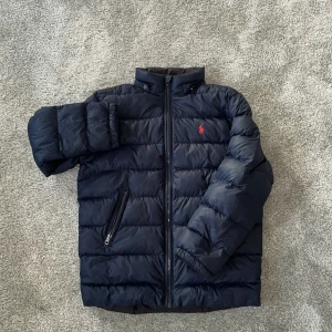 Ralph Lauren Jacka - Hej! Säljer min Ralph Lauren Jacka för att den har blivit för liten. Nypris ~ 4000kr. Den har en avtagbar luva som är väldigt bra om det är lite ruggigt väder ute. Den har en Polo logga på Höger arm. Perfekt för en lite stiligare look nu till våren! Skriv om ni vill ha mer bilder eller om ni har några frågor! Jag svarar Snabbt :)  P.S! Kan gå ner i pris vid snabb affär