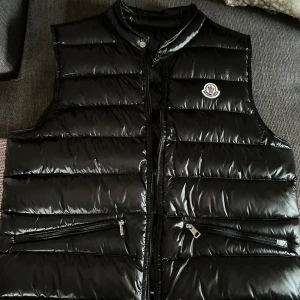 Svart väst Moncler - Snygg svart moncler väst som är Perfekt för kyligare dagar när du vill hålla stilen. Det är jätte fint utan skador! Jag säljer den eftersom använder inte den! Haft den cirka 5 månader men för de mera har det vart hemma! M men sitter S. Pris går att diskutera lite 
