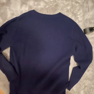Mörkblå tröja - Säljer en stilren mörkblå tröja med långa ärmar. Perfekt för kyligare dagar och enkel att matcha med olika outfits. 100% Kashmir.