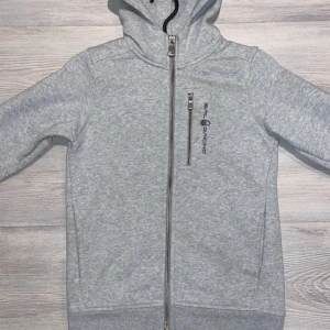 Grå hoodie från Peak Sail Racing - Säljer en stilren grå zip hoodie från Sail Racing. Barnstorlek 140