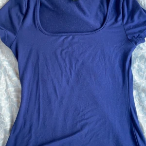 Blå kortärmad topp - Säljer en stilren blå kortärmad topp med rund halsringning. Perfekt för en avslappnad look.