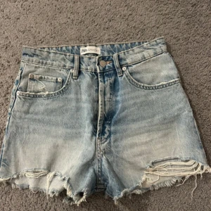 Blå jeansshorts från Zara - Snygga blå jeansshorts från Zara med slitna detaljer och fransar vid benen. Använda fåtal gånger men är som i nyskick😻