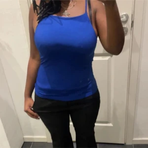 Blå ärmlös linnetopp - Snygg blå ärmlös linnetopp med smala axelband. Perfekt för varma dagar eller som ett lager under en jacka. Enkel och stilren design som passar till det mesta.