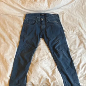 Blå jeansbyxor från Replay - Snygga blå jeansbyxor från Replay, modell Anbass. De är i väldigt bra skick och är använda ungefär 15 gånger. Säljer dem på grund av att de inte passar mig. Nypris ligger på 1899 och jag säljer dem för 599. Kan även gå ner lite i pris vid snabb affär.